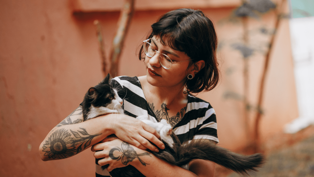 A couple holding a cat in their living room