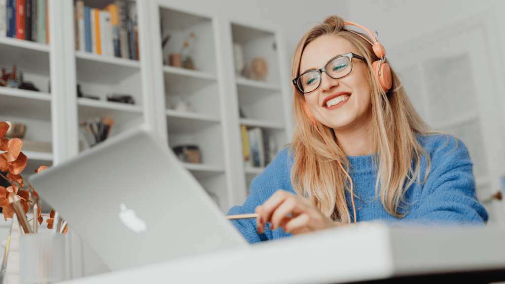 A person smiling while working on a laptop 