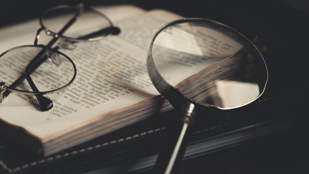 glasses and magnifying glass on an open book