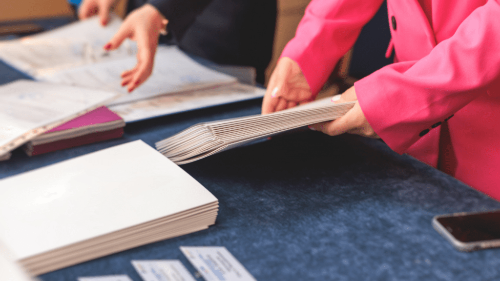 a person in a pink suit is holding a stack of papers