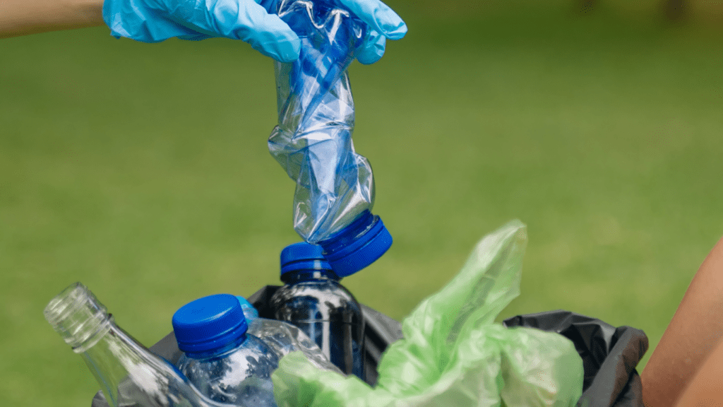 Two people in blue gloves are holding a plastic bag